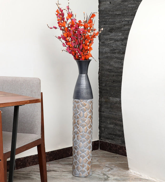 Crafted of metal, this stunning vase strikes an updated amphora silhouette with a 32" H x 8" W cylindrical body and a flared mouth. Perfect for long-stemmed florals, decorative twigs, or unfilled as a sculptural accent, Its ambiguous qualities make it a magnetic piece that guests won't be able to keep their eyes off of. This vase can be simply wiped with a dry cloth for effortless upkeep.