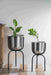 Bring a taste of the green outdoors into the comfort of your own home with just the addition of some fresh plants. Use this modern inspired pot planter to grow your favorite flower, cactus, herb and more. It features a geometric stand, that allows this piece to be placed on the ground next to a desk, fireplace, or seating arrangement. The planter itself is crafted from galvanized metal.